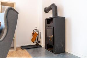 a black stove in a room with a chair at Ferienhaus Sternchen 3 in Schwarz