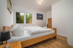 a bedroom with a bed with white sheets and a window at Ferienhaus Sternchen 3 in Schwarz