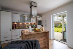a kitchen with a counter with a bowl of fruit on it at Ferienhaus Spiekeroog- Müritz in Zielow +26 photos