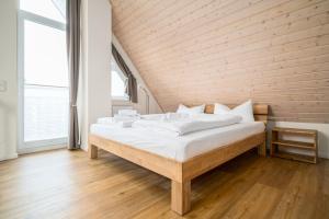 a large bed in a room with a wooden wall at App Kapitänsdeck 415 am Müritzufer in Rechlin