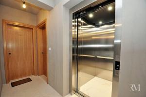 a walk in closet with a stainless steel refrigerator at DS Apartment in Dobrota