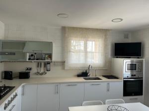 A kitchen or kitchenette at Piscina de sal Barbacoa Wifi, Parking Gratis, 3 min PGA Casa El Roble