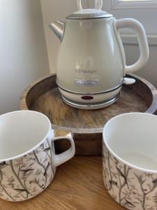 a tea kettle and two cups on a wooden tray at Woodland House B & B in Wimborne Minster