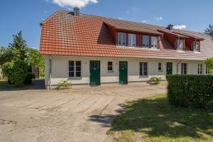 a house with green doors and a red roof at Ferienappartement Müritzkoje in Vipperow