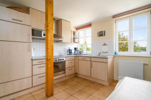 a kitchen with white cabinets and a stove top oven at Ferienappartement Müritzkoje in Vipperow