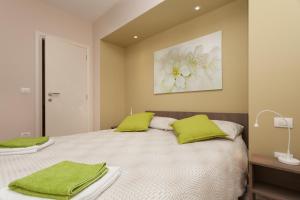 a bedroom with a large bed with green pillows at Apartments Alice in Rovinj