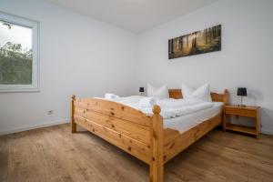 a bedroom with a wooden bed with white sheets at Ferienhaus Sternchen 2 in Schwarz