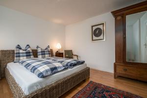 een slaapkamer met een bed met geruite kussens en een spiegel bij Ferienwohnung 1 im Landhaus am Wildpark Boek in Boek