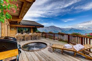 a deck with a grill and tables and chairs at Chalet la Couronne in La Tzoumaz
