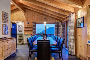 a dining room with a table and blue chairs at Chalet la Couronne in La Tzoumaz +26 photos