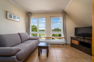 a living room with a couch and a flat screen tv at Ferienappartement Müritzblick in Vipperow
