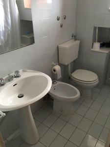 Baño blanco con lavabo y aseo en Ca da Lalla en Carro