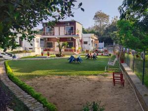 una casa con un parque infantil delante de ella en Anugraha Homestay en Rāmnagar