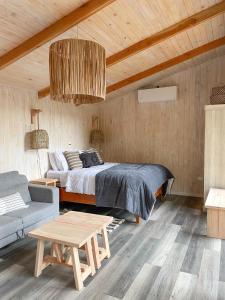 a bedroom with a bed and a couch and a table at Cabañas Los Huemules in Malalcahuello