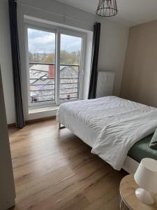 a bedroom with a bed and a large window at Pina's Appartment in Namur