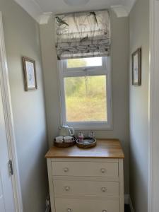 a dresser in a room with a window and a dresser at Woodland House B & B in Wimborne Minster