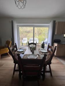 a dining room with a table and chairs and a room with a window at Pina's Appartment in Namur