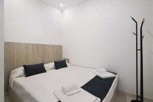 een slaapkamer met een wit bed en 2 handdoeken bij Casa Anzol in Fuzeta