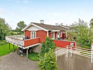 ein rotes Haus mit einer Terrasse und einem Zaun in der Unterkunft Holiday home Aabenraa LXIX in Aabenraa