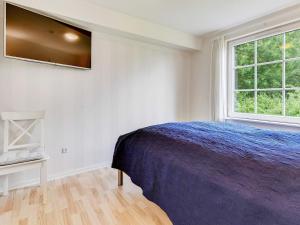 a bedroom with a bed and a tv on the wall at Holiday home Aabenraa LXIX in Aabenraa