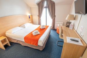 um quarto de hotel com uma cama grande e uma secretária em Hôtel Saint Laurent em Nogent-sur-Seine