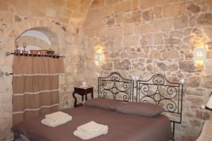 een slaapkamer met een bed in een stenen muur bij Malta & Tufo in Altamura