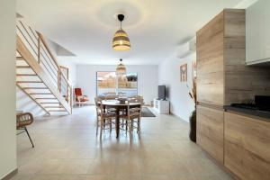 een keuken en eetkamer met een tafel en stoelen bij L'Hirondelle Blanche - 4 étoiles in Dolus d'Oléron