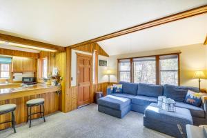 a living room with a blue couch and a kitchen at Hungry Horse Cabin with Gas Grill, Near Glacier! in Hungry Horse