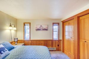 1 dormitorio con 1 cama y 2 ventanas en Hungry Horse Cabin with Gas Grill, Near Glacier! en Hungry Horse
