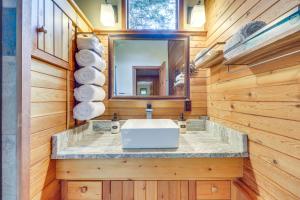 a bathroom with a sink and a mirror at Hungry Horse Cabin with Gas Grill, Near Glacier! in Hungry Horse +26 photos
