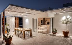 ein Esszimmer mit einem Tisch und ein Wohnzimmer in der Unterkunft Sea View Beach Penthouse - Athens Coast in Athen