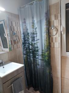 a bathroom with a shower curtain with a forest at Boutique Kalithea in Athens