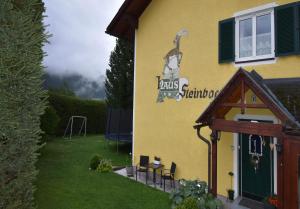 a yellow building with a sign on the side of it at Apartments Haus Steinbock in Tauplitz