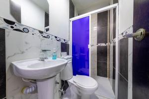 een badkamer met een wastafel, een toilet en een douche bij Hotel Confort Obelisk in Medellín