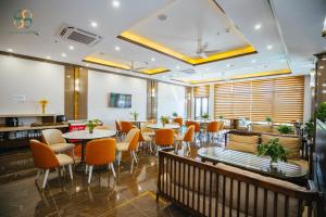 a restaurant with tables and chairs in a room at Ha Long Seasun Hotel in Ha Long