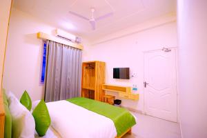 - une chambre avec un lit et une télévision dans l'établissement Around Stays Hostel Rishikesh, Tapovan, à Rishikesh
