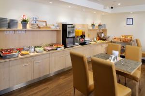 a kitchen filled with lots of food and a table at Promenade City Hotel in Budapest