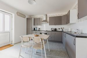 a kitchen with a table and chairs in a room at Hullidays - Theatre Side Apartment - Refurbished 2023 in Hull