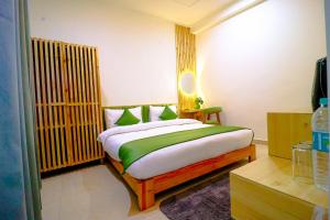 - une chambre dotée d'un lit avec des draps verts et blancs dans l'établissement Around Stays Hostel Rishikesh, Tapovan, à Rishikesh