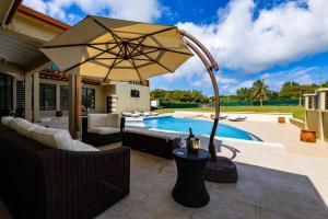 a patio with an umbrella next to a swimming pool at Villa Belle in Egmont