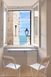 a room with a window with a view of the ocean at Dimora nel Palazzo Ducale in Giovinazzo