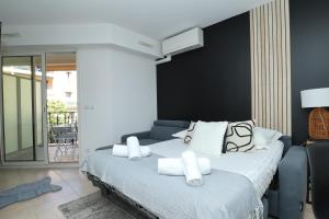 una camera da letto con un grande letto con cuscini bianchi di "Le beach", plein centre, climatisé a Mentone
