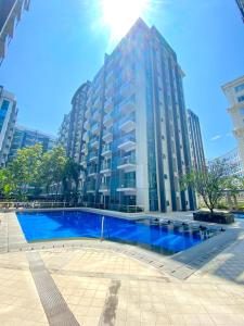 a large building with a large blue swimming pool at Condo in Newport City Pasay near NAIA T3 AIRPORT MANILA in Manila