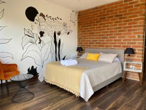 バジェ・デ・グアダルーペにあるPalta 60 Valle de Guadalupeのレンガの壁、ベッド付きのベッドルーム1室