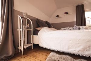Schlafzimmer mit einem weißen Bett und einem Spiegel in der Unterkunft Pfälzer Herzel in Neustadt an der Weinstraße