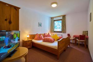 1 dormitorio con 1 cama con almohadas rojas y amarillas en Gasthof Lamm, en Sankt Jodok am Brenner