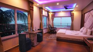 una habitación de hotel con una cama y un balcón en Sher Bengal Beach Resort, en Mandarmani