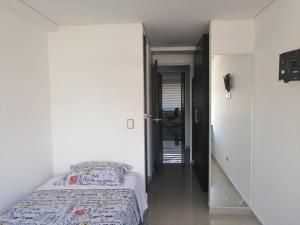 a small bedroom with a bed and a hallway at Seganis casa hotel in Bogotá