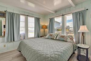 a bedroom with a bed and two large windows at Sunny Freeport Beach House Rental Near Shore in Freeport