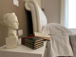 una statua di una testa su un tavolo con dei libri di Pompei via Roma Suite a Pompei